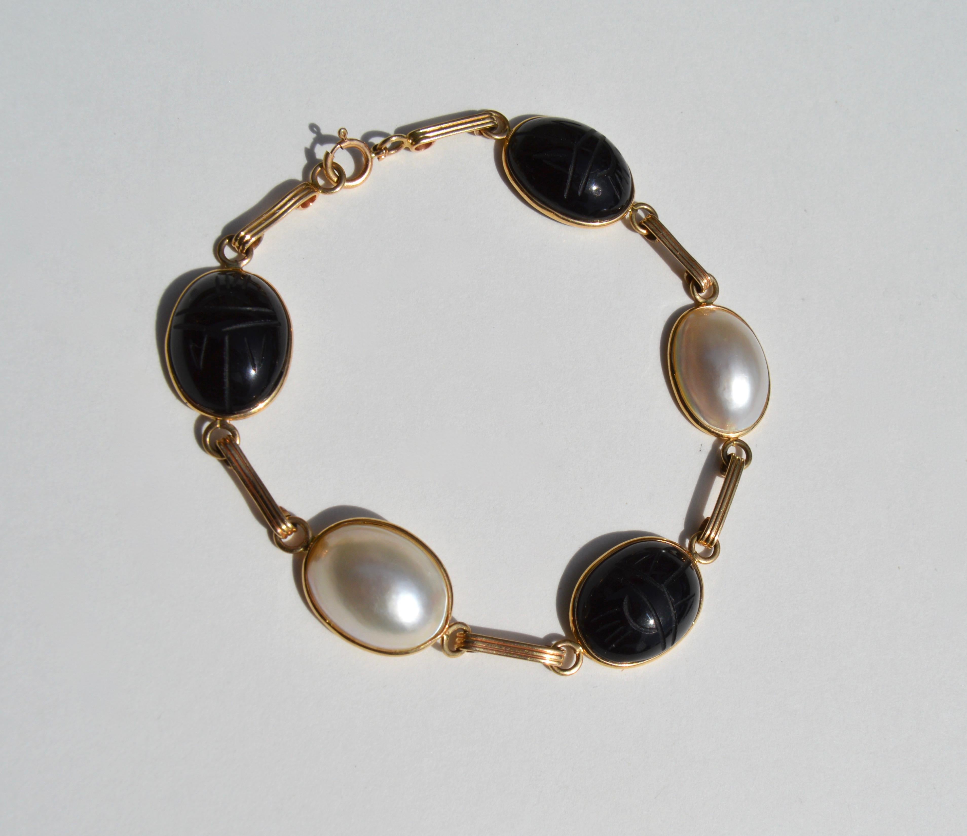 Beautiful vintage midcentury era circa 1960s Egyptian revival 14K yellow gold with mother of pearl and hand carved onyx scarab beetles. In very good condition. Bracelet measures 7