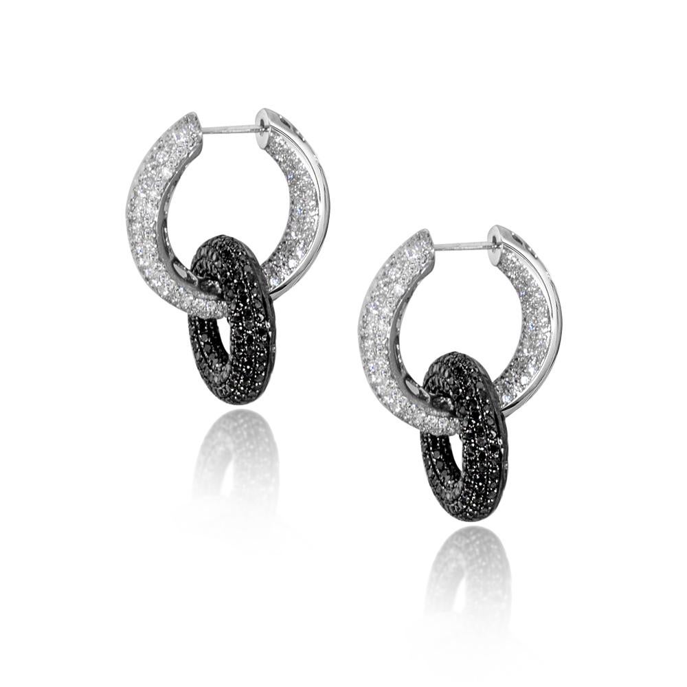 These glamorous and ultra-chic interlocking hoop earrings feature 3.20 carats of white diamonds and 3.20 carats of black diamonds micro pavé set in 18 karat gold. The black diamond hoops can be removed easily and you can wear the white diamond hoops