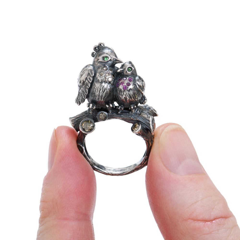 Limited edition patinated silver ring by Sylvie Corbelin with two Love Birds on the top of the mount.
The mount representes a tree branch where champagne diamonds are set.
Diamonds weight : 0,68 carats
Ruby : 0,14 carats
Tsavorite : 0,04