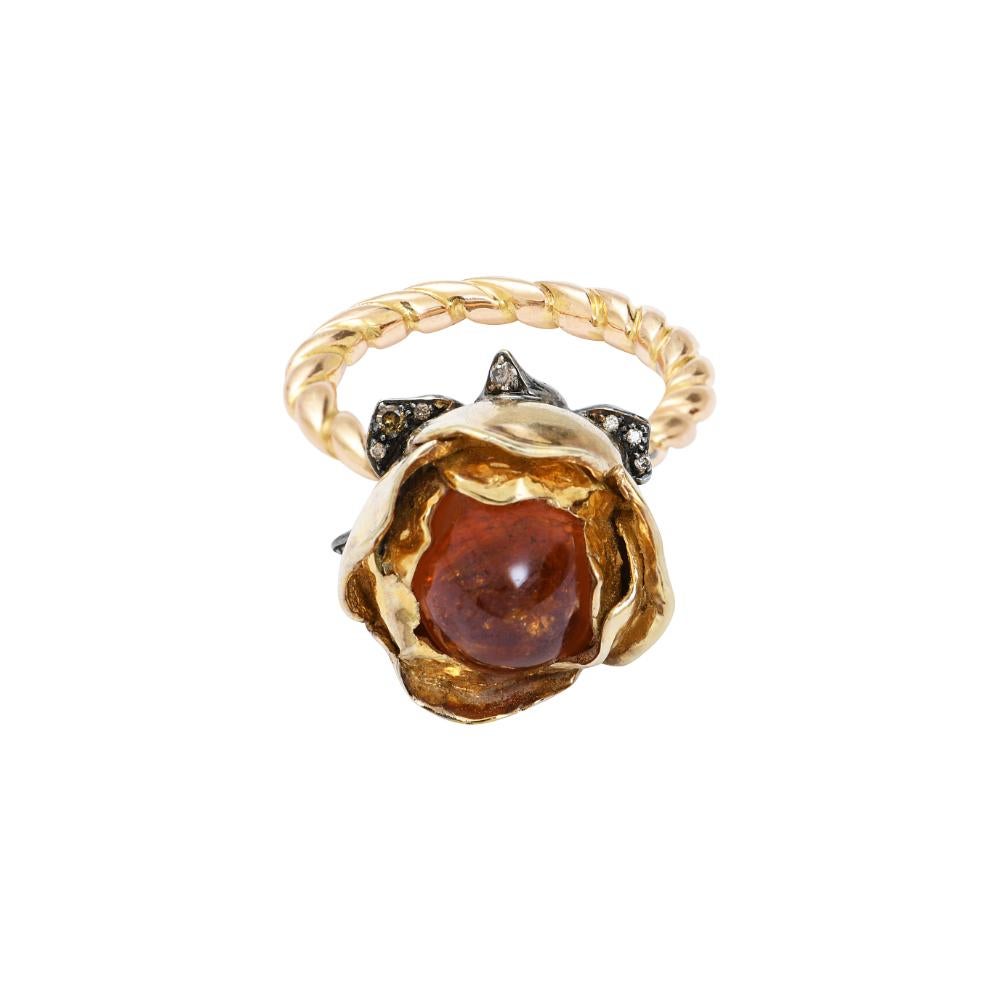 One of a kind rose flower ring in yellow 750/1000 gold (18K) and vermeil by Sylvie Corbelin.
The rose flower is set with a spessartite cabochon in vermeil. The corolla of the flower is set with champagne diamonds in patinated silver.
Vermeil : 15