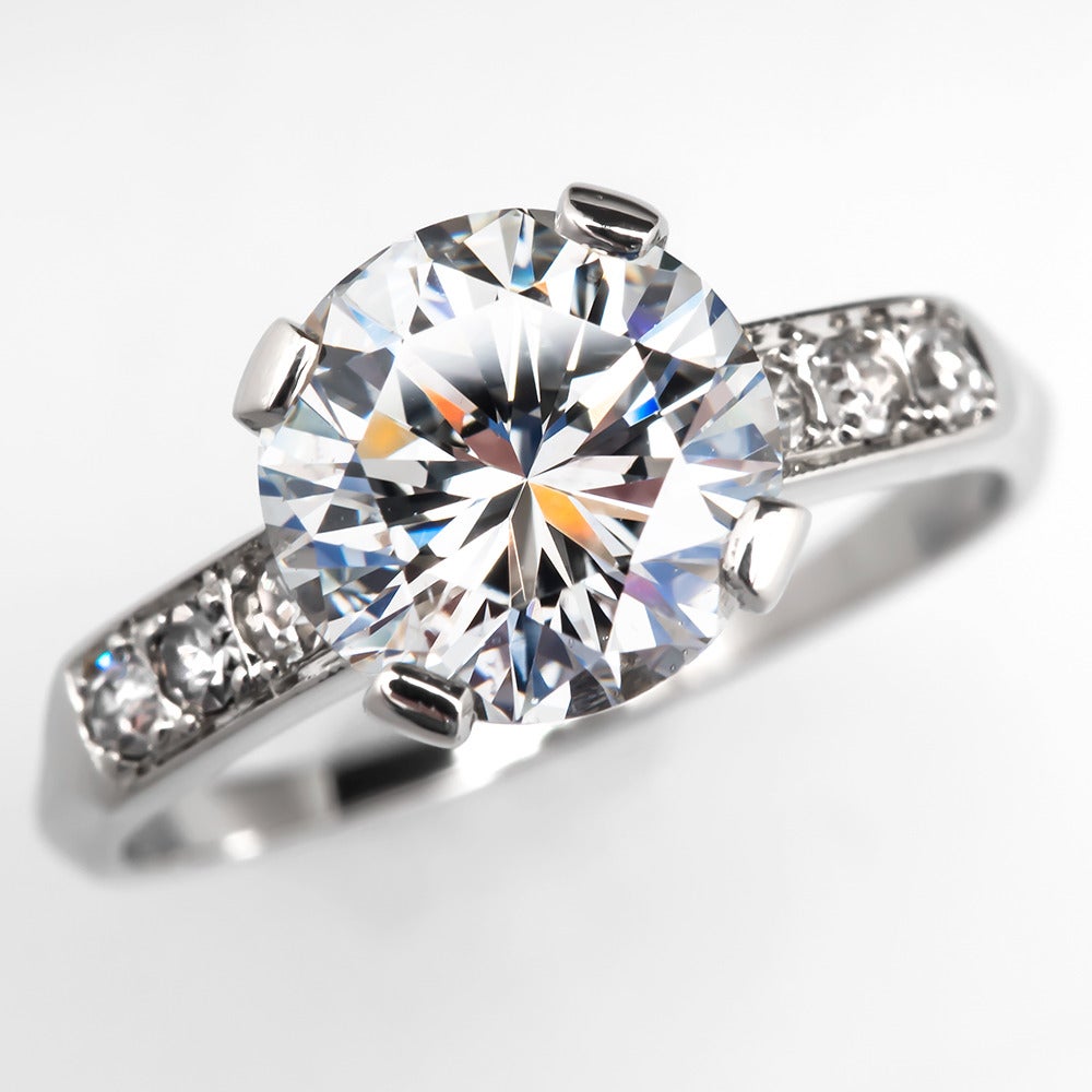 This gorgeous diamond engagement ring is centered with a 2.06 carat GIA Certified round brilliant cut diamond grading a G in color and SI1 in clarity. This diamond has very good cut, polish, and symmetry and medium blue fluorescence. Each shoulder