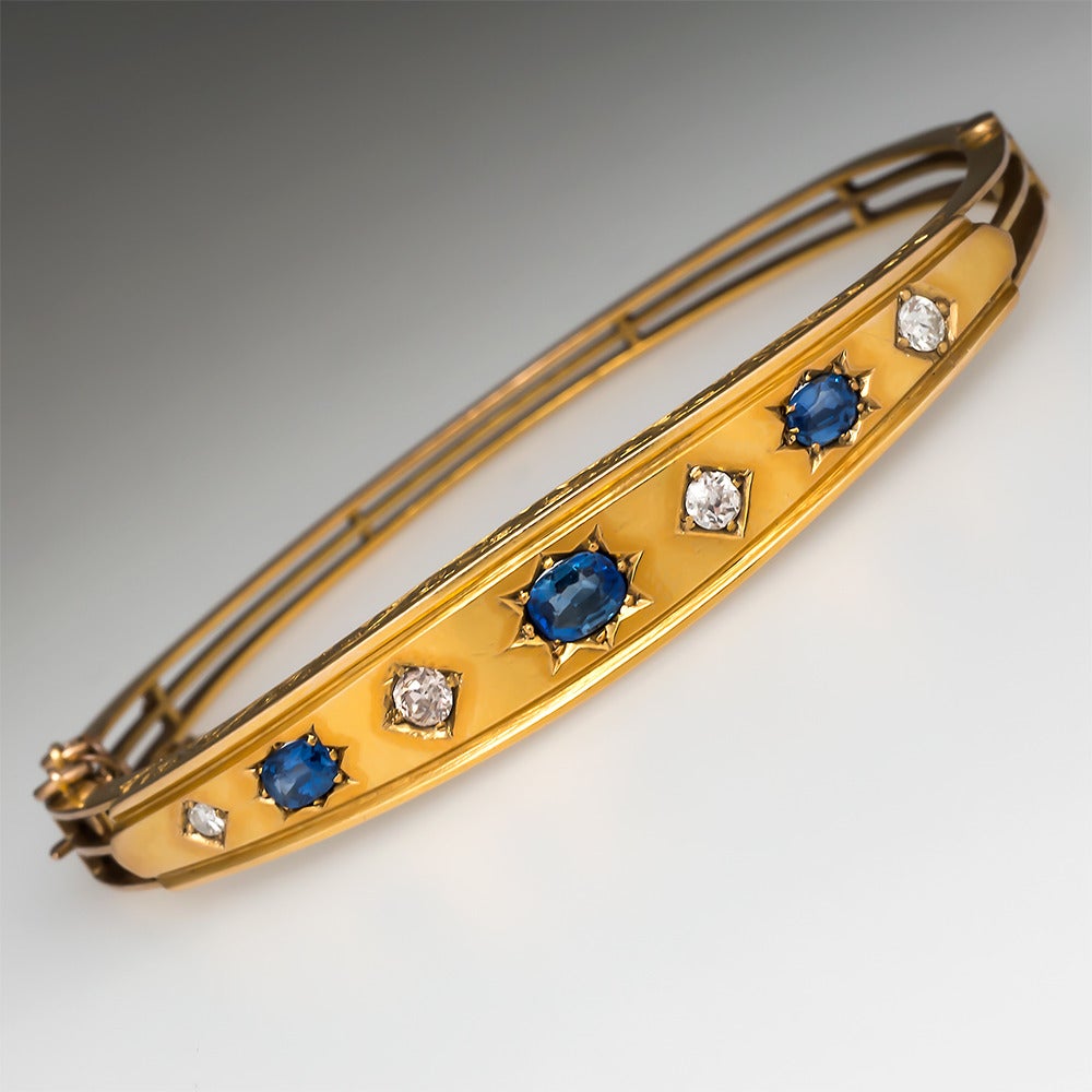 The top of the bracelet is set with alternating oval cut natural blue sapphires and old Euro cut diamonds set into star and diamond shaped settings. The profile of the top section of the bracelet shows hand etched scrolling patterns and the bottom
