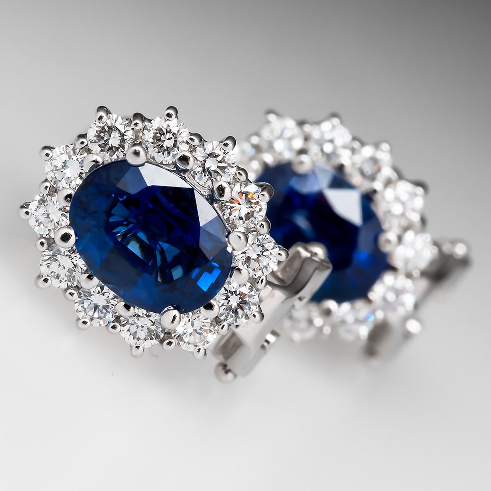 These lovely estate stud earrings feature natural blue sapphire stones totaling 3.20 carats that are surrounded by fiery bright genuine natural diamonds. These earrings are crafted of solid 18k white gold and are in very good condition. The earrings