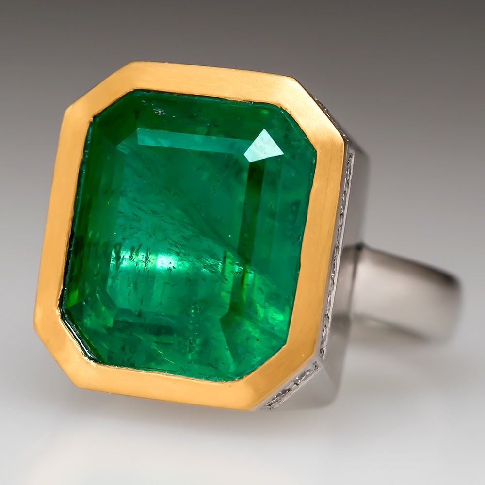 EraGem designed this ring to make a statement. The massive 14 carat emerald is set in a rich 22k yellow gold bezel atop a heavy solid platinum mounting. The accent diamonds are very high quality and complement the emerald beautifully. An emerald of