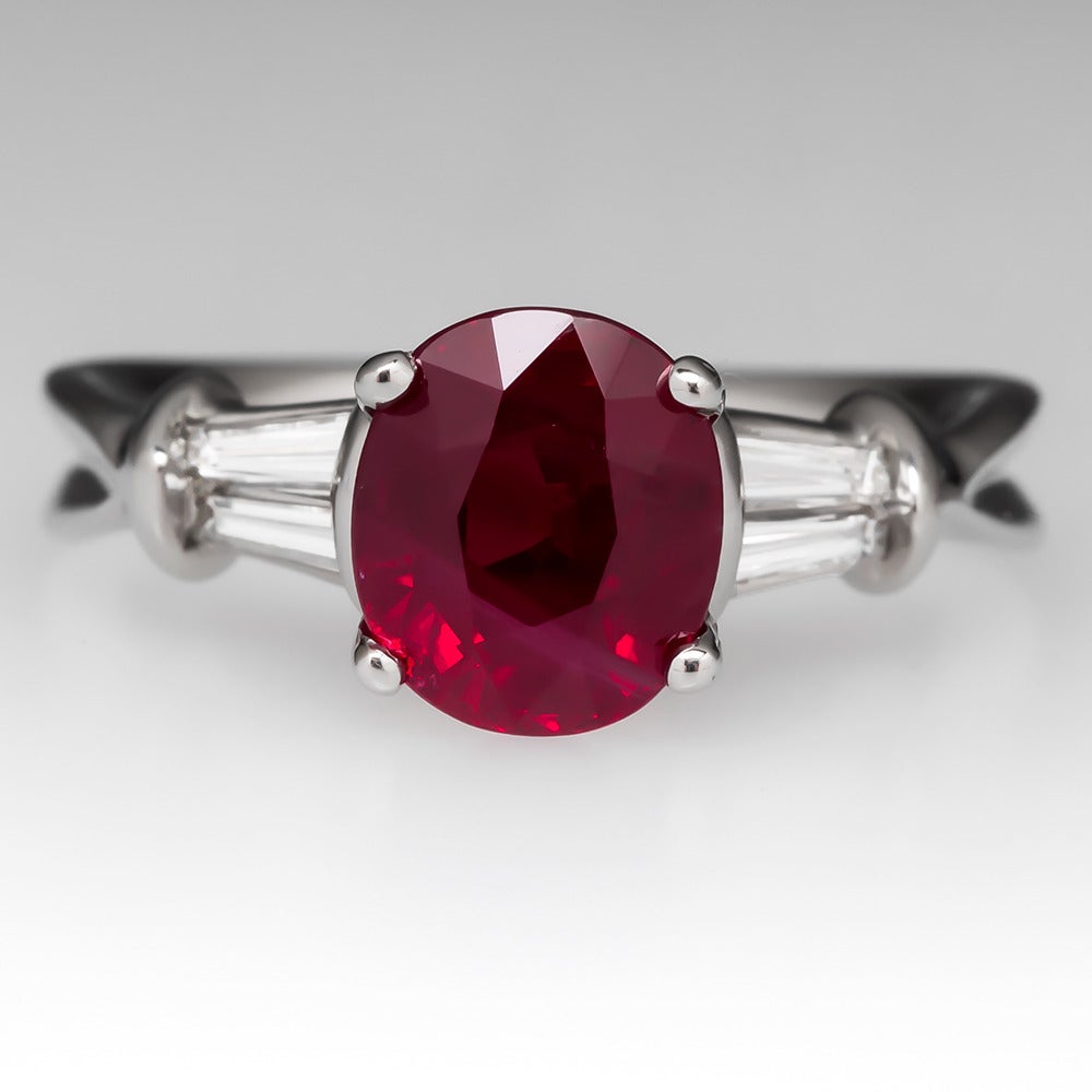 This magnificent ruby engagement ring features one of the finest rubies we have ever seen, a stunning 3.04 carat natural oval cut with outstanding color. Four tapered diamond baguettes grading f-g/vs2-si1 totaling .30 carats accent the center stone