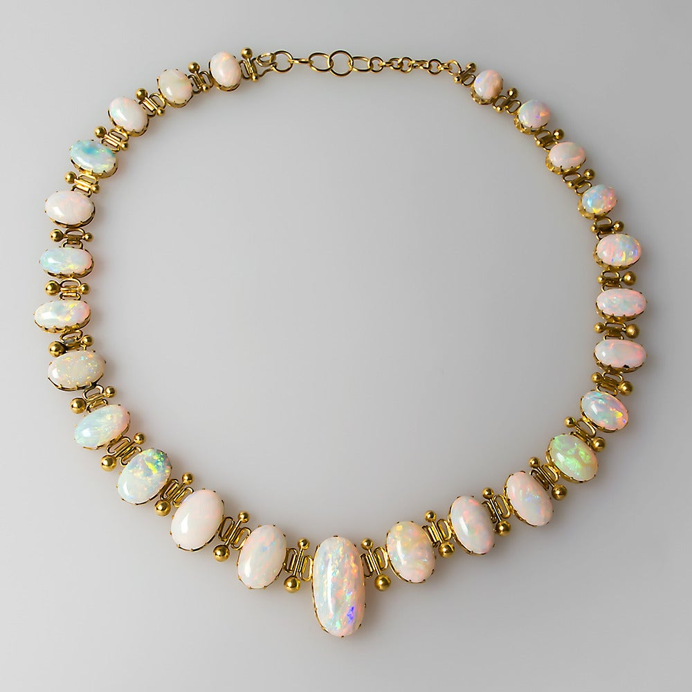 This magnificent 1920's antique opal necklace is artfully crafted of solid 18k yellow gold. The opals in this necklace are truly spectacular and need to be seen to be truly appreciated. The opals total a substantial 80.7 carats. The necklace can be