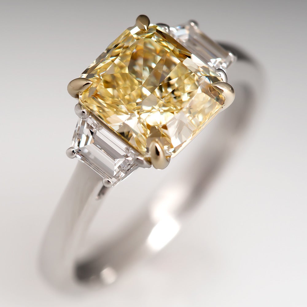 This magnificent fancy yellow diamond engagement ring features a breathtaking GIA certified non-enhanced 2.15 carat center diamond. The fancy yellow color is evenly distributed and natural. The clarity is a near perfect VVS1. This diamond is out of