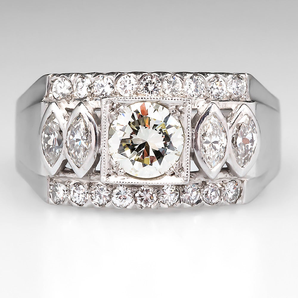 This handsome gent's ring is centered with a .72 carat diamond grading K in color and a near perfect VVS1 in clarity with very good cut and polish grades. The center diamond is accented with 2 bezel set marquise diamonds set at each shoulder and