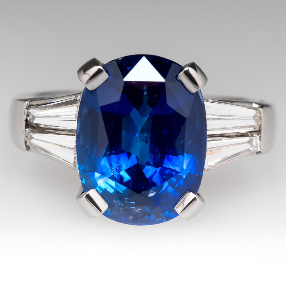 This Sri Lankan stunner is GIA certified and weighs nearly 8 carats. The size and violetish blue color of the cushion cut sapphire are truly magnificent. This stunning ring is crafted of solid platinum. The sapphire is flanked on each side by two