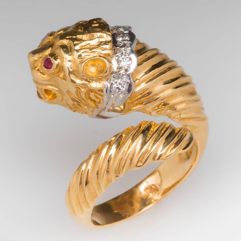 This incredible Ilias Lalaounis Lion Head ring features natural rubies and diamonds. The ring is crafted of solid 18k yellow gold and the diamonds are set in white gold. The ring is intricately detailed and carved to the finest detail. It fits like