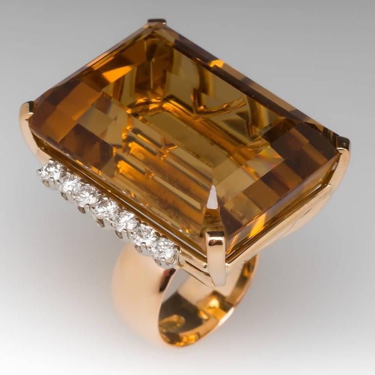 This vintage cocktail ring is massive and magnificent. The citrine weighs approximately 80 carats and is accented on each side by a row of round brilliant diamonds. The ring is crafted of solid 18k yellow gold and the diamonds are individually set