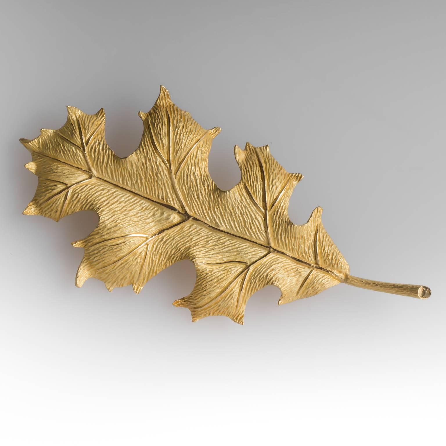 This Tiffany & Co oak leaf brooch pin is crafted of solid 18k gold and has lifelike details.