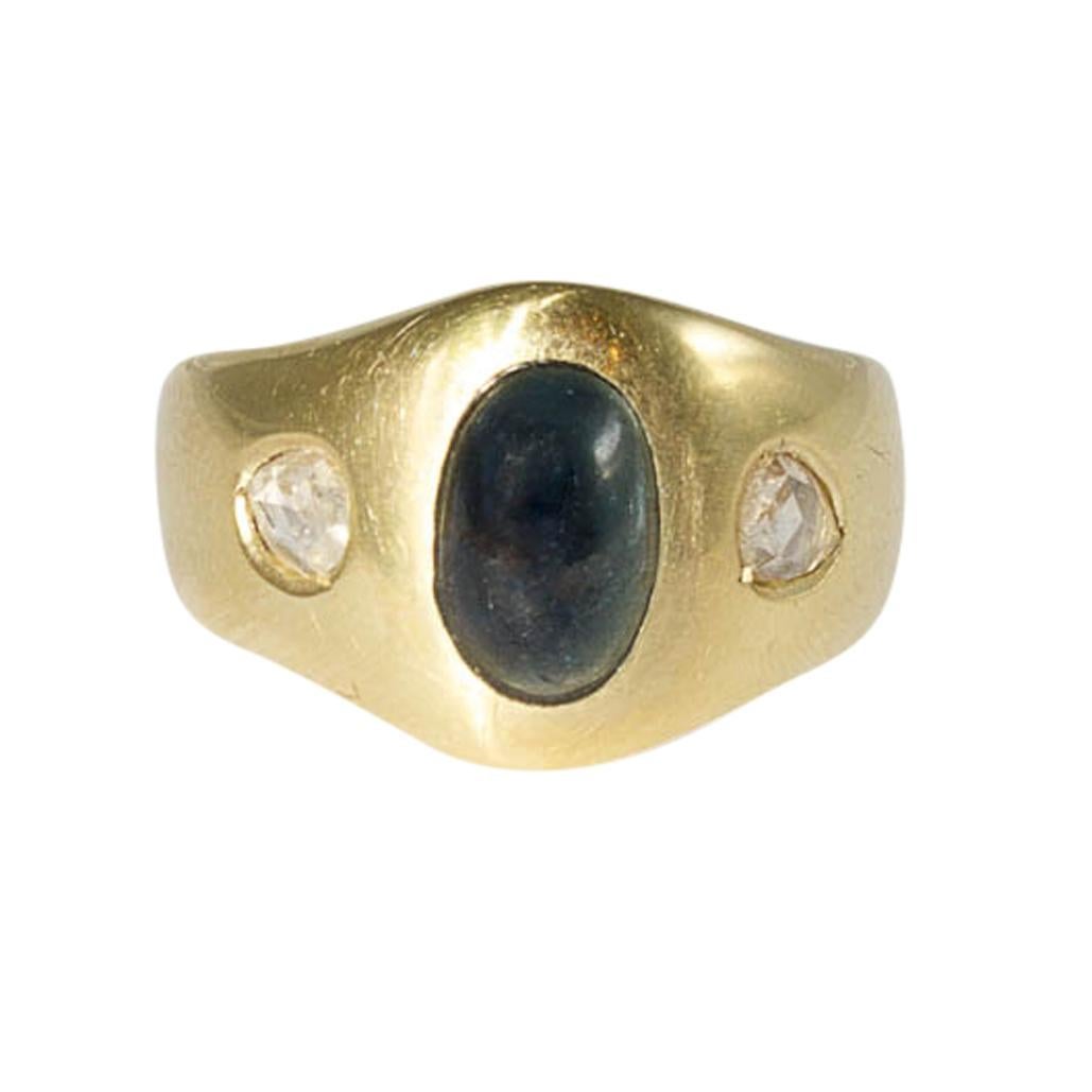 Bandring yellow gold with sapphire cabochon and diamonds

large ring in yellow gold with a cabochon-cut central sapphire accompanied by 2 old-cut diamonds of ca. 0,2 ct

Ring width: D 59, US 8.7

Total weight: 12.2 g