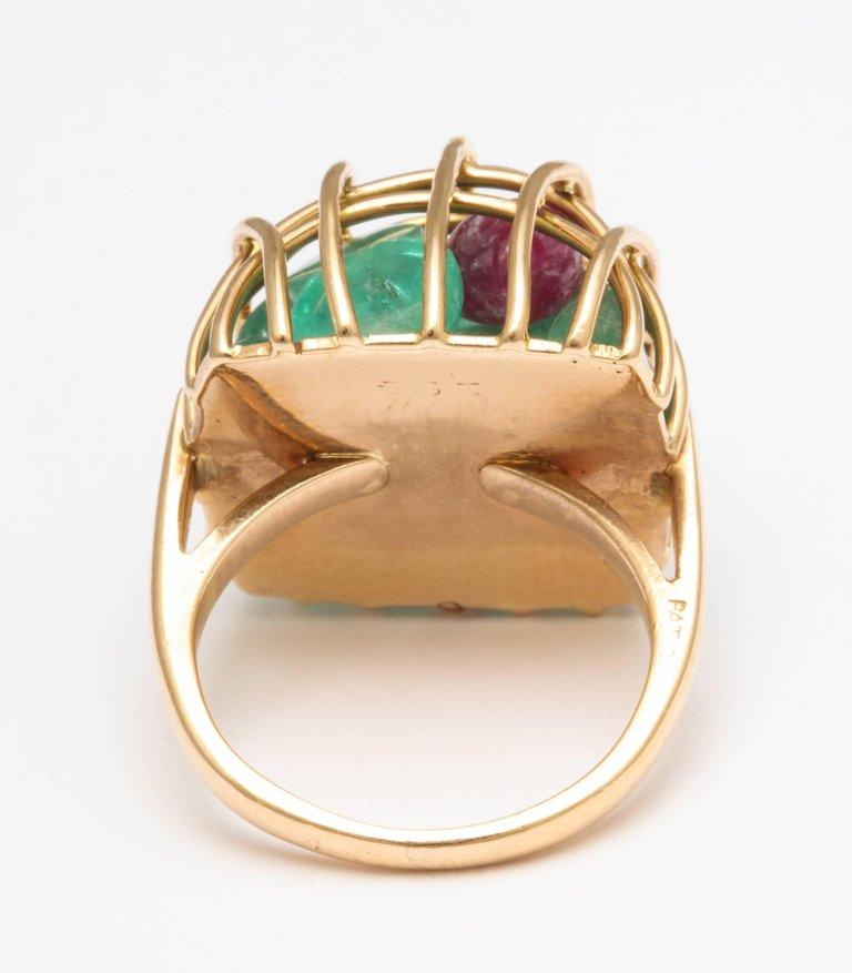 An enchanting cage of gemstones in 18 kt gold with loose emeralds and rubies