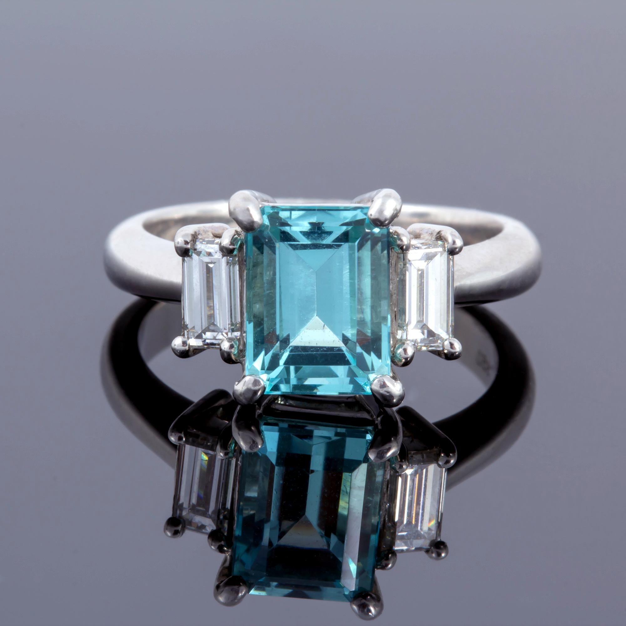 Set in platinum, this rare Paraiba tourmaline gem centered between two diamond baguettes.  Can be sized to fit anyone.  Loupe clean and stunning engagement ring offering one of the rarest stones in the world.

Created by noted jewelry designer David