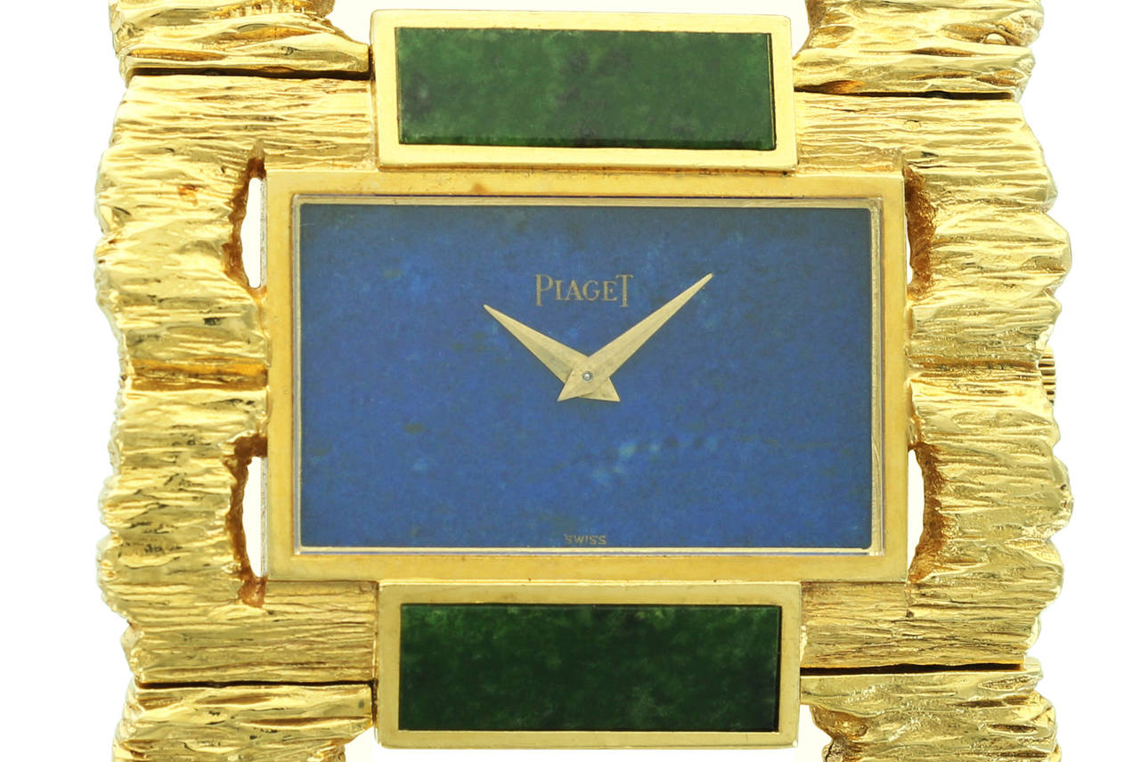 This rare and beautiful Piaget ladies cuff features bark-finished yellow gold, lapis lazuli and nephrite links and a watch with lapis lazuli dial. This is certainly a rare find from an amazing period in Piaget's history and would be a remarkable
