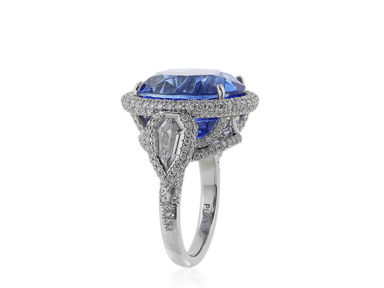 Platinum, custom made ring, featuring 1 oval Cushion cut Ceylon Sapphire weighing 20.86 carats, flanked by 2 kite shaped diamonds and accented with pave set full cut diamonds.