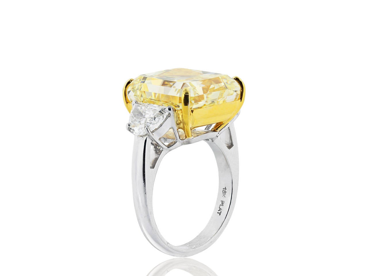 Platinum and 18 karat yellow gold, three stone style engagement ring consisting of 1 radiant cut canary diamond, weighing 14.63 carats, measuring 13.54 x 12.60 x 8.70 mm, having a color and clarity of Fancy Yellow/VS1 with GIA report number