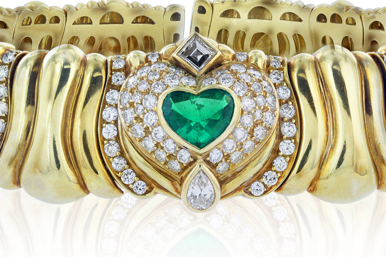 18 karat yellow gold collar necklace consisting of 1 heart shape emerald weighing approximately 1.32 carats, 2 oval cut emeralds having an estimated total weight of 1.92 carats, 3 square step cut diamonds having an estimated total weight of 1.13