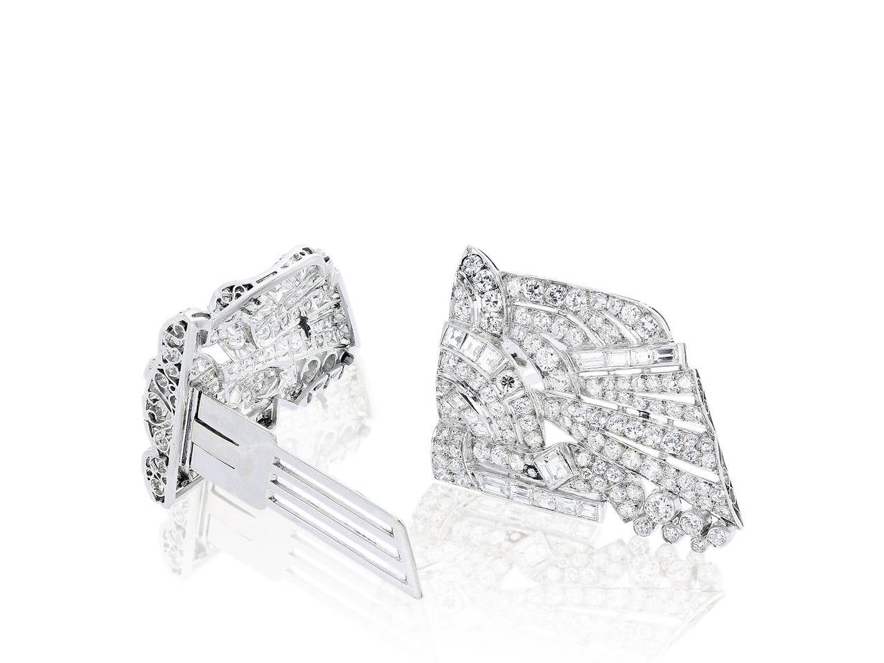Platinum Art Deco Geometric motif clips and pin consisting of full cut, square and baguette diamonds having an estimated total weight of 12.00 carats.