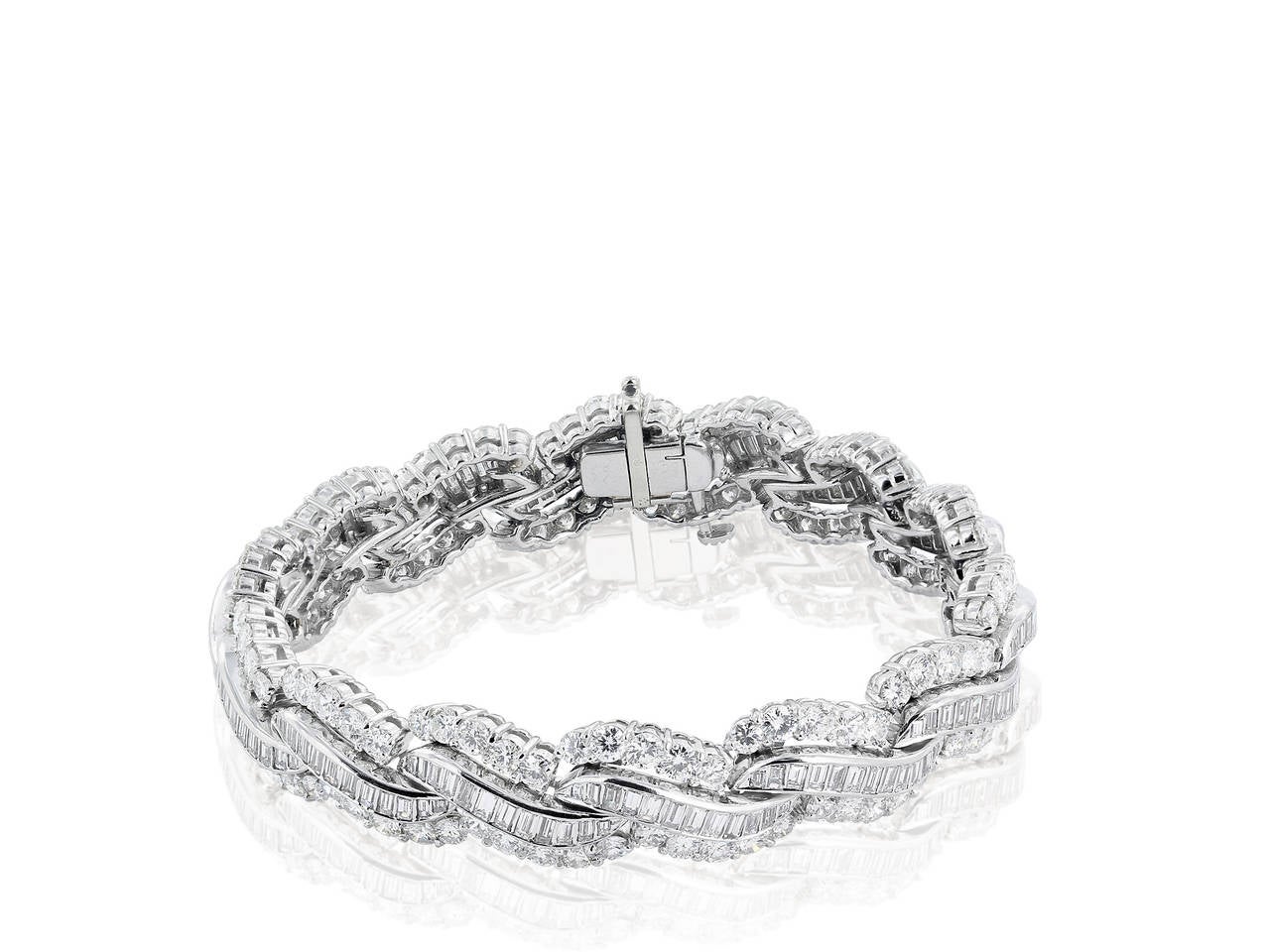 Retro style platinum flexible link bracelet, consisting of 168 channel set baguette diamonds having an estimated total weight of 7.00 carats set in between two rows of 140 prong set round brilliant cut diamonds having an approximate total weight of