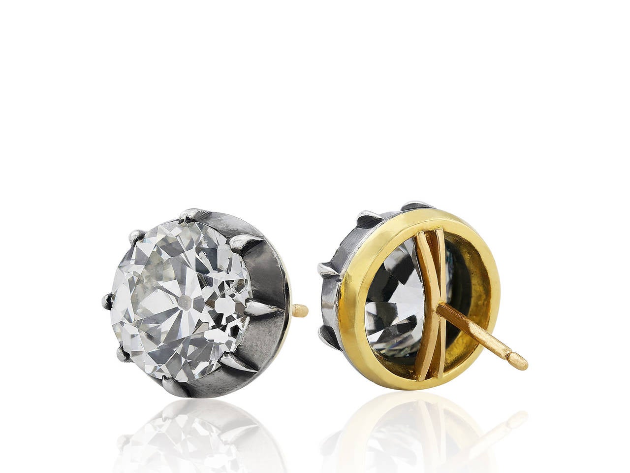 Sterling silver on 14 karat yellow gold vintage style stud earrings consisting of 2 Old European cut diamonds having a total weight of 8.18 carats, one diamond weighing 4.02 carats, the second weighing 4.16 carats.