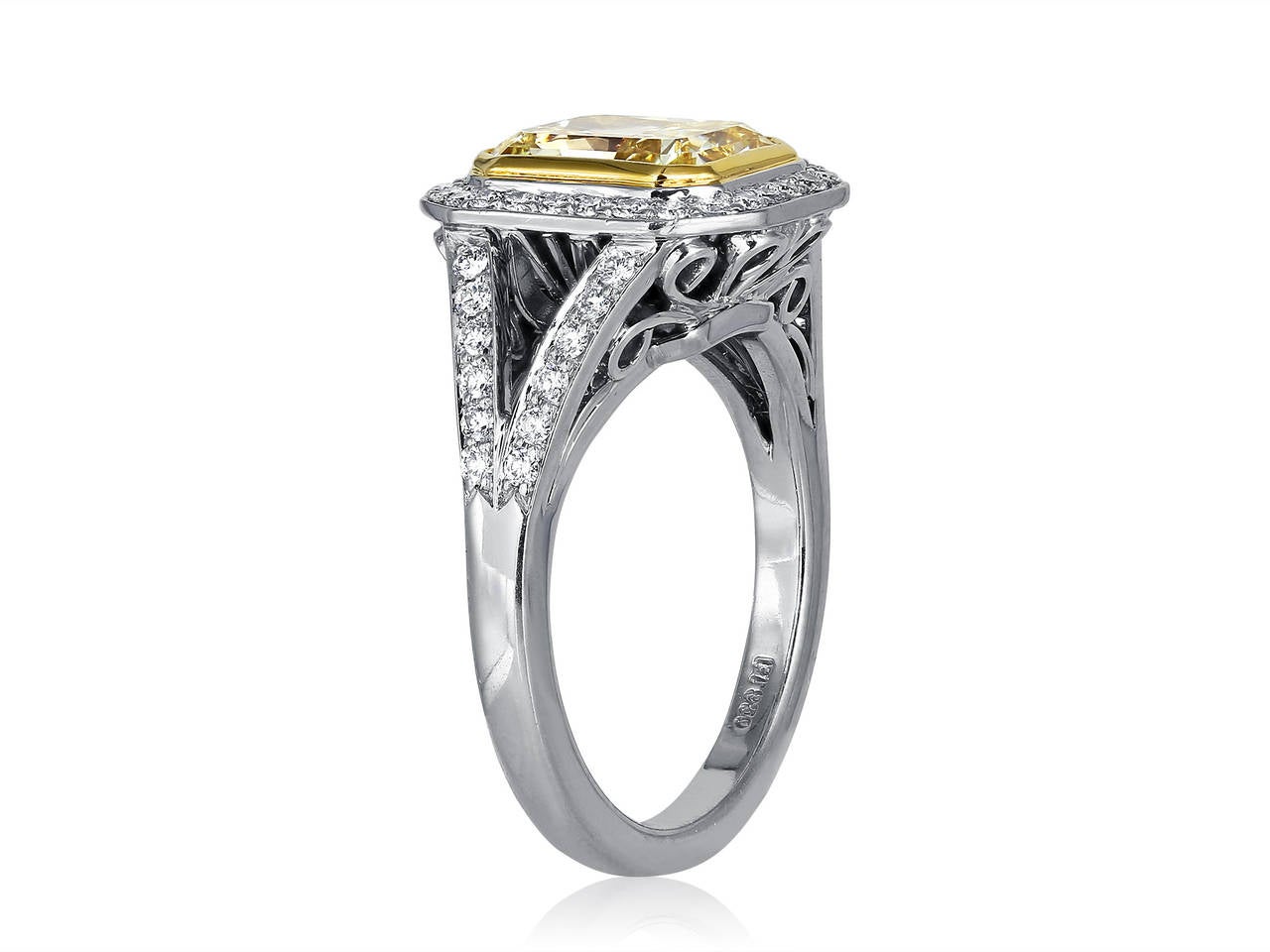 Platinum and 18 karat yellow gold custom made halo ring consisting of 1 bezel set rectangular radiant cut natural canary diamond weighing 2.88 carats, having a color and clarity of fancy yellow/SI1 respectively, measuring 8.77 x 7.06 x 4.81mm, with