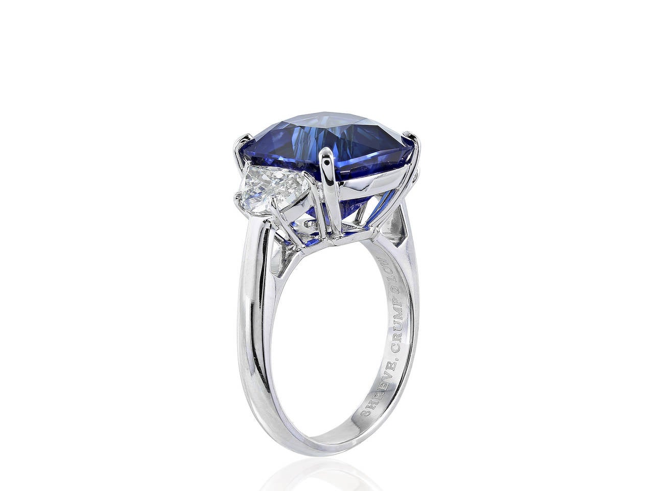 Platinum custom made three stone ring consisting of 1 cushion cut deep blue sapphire weighing 11.14 carats, measuring around 12.45 x 11.70 x 9.00 mm and flanked by 2 half moon cut diamonds having a total weight of 1.32 carats and an approximate