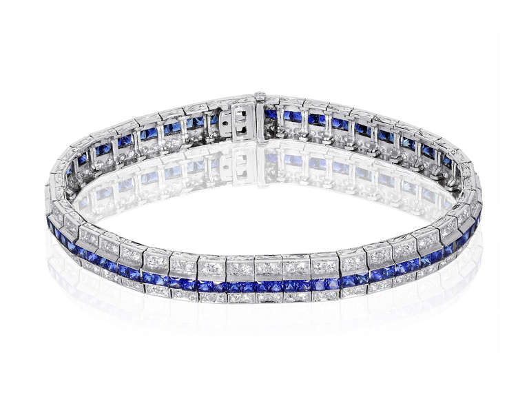 Art Deco platinum flexible line bracelet consisting of a single center row of 86 channel set french cut natural blue sapphires having an estimated total weight of 5.16 carats with two rows of bead set 172 old European cut diamonds, one on each,