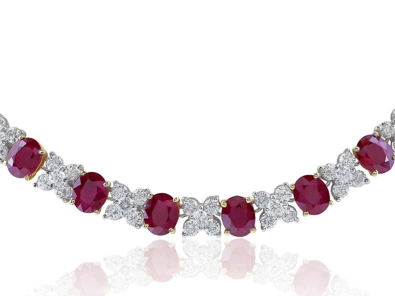 Two tone 18 karat yellow and white gold uniform necklace consisting of 39 oval shaped Burma rubies having a total weight of approximately 23.40 carats alternating with 195 round brilliant cut diamonds having a total weight of approximately 9.75