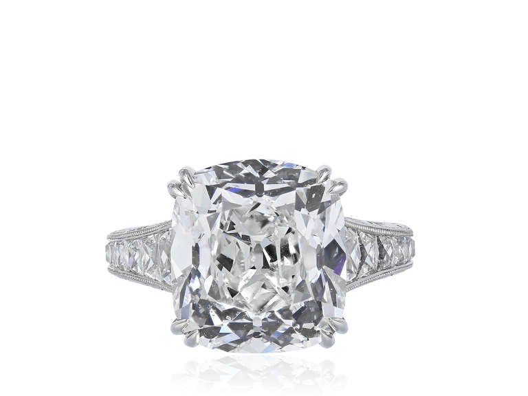 Platinum and diamond ring consisting of a 10.05 carat cushion cut diamond with GIA certificate 2155614533 with a color and clarity grade of H SI 1 respectively, set in a platinum hand engraved mounting with approximately 1.61 carats of french cut