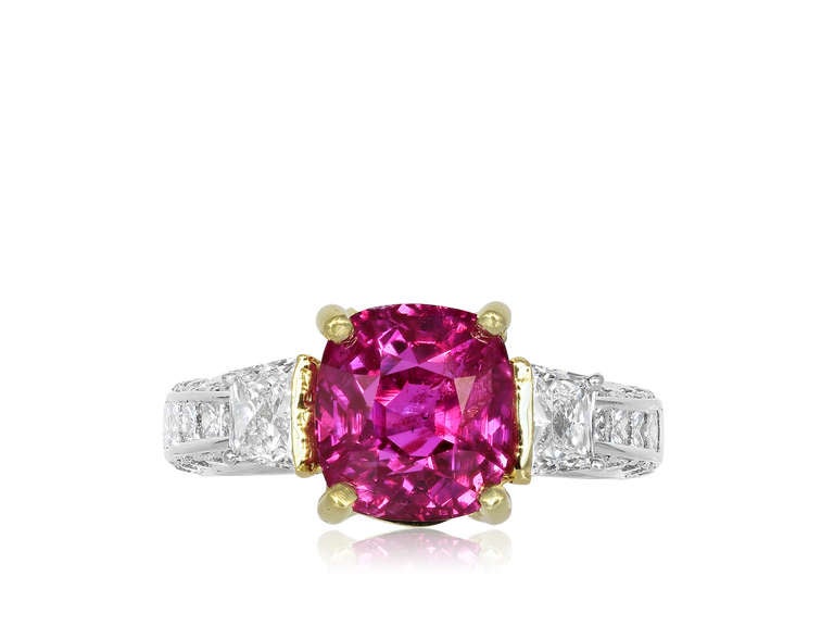Platinum and 18 karat yellow gold custom made 3 stone ring consisting of 1 cushion cut Ruby(GIA) weighing 5.18 carats, measuring approximately 8.99 x 8.20 x 7.40 mm, the center stone is flanked by 2 brilliant cut trapezoid diamonds with channel set