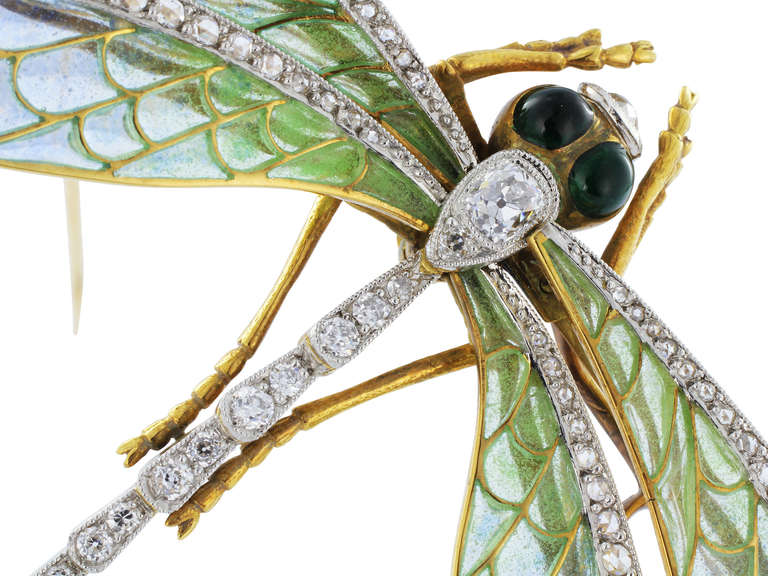 18 karat yellow gold antique style en tremblant dragonfly pin with green and blue plique-a-jour wing, set with 2.41 carats total weight of antique cut diamond accents set in the torso and on the wings and cabochon green sapphire eyes.