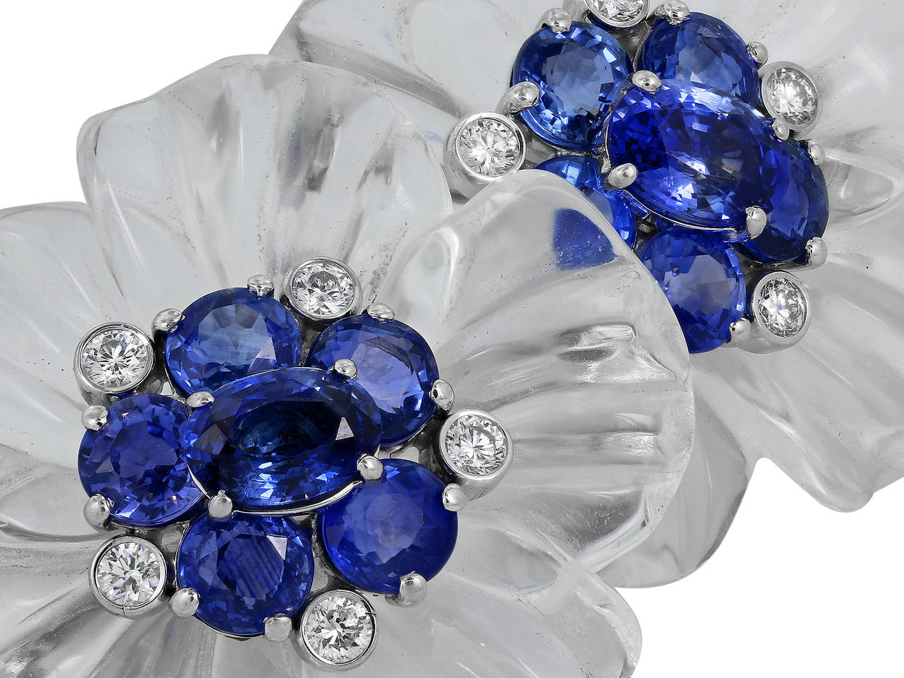 18 karat white gold carved crystal floral motif earrings consisting of 12 oval and round shaped blue sapphires having a total weight of 8.00 carats set with 10 bezel set round brilliant cut diamonds having a total weight of .60 carats, signed Aletto
