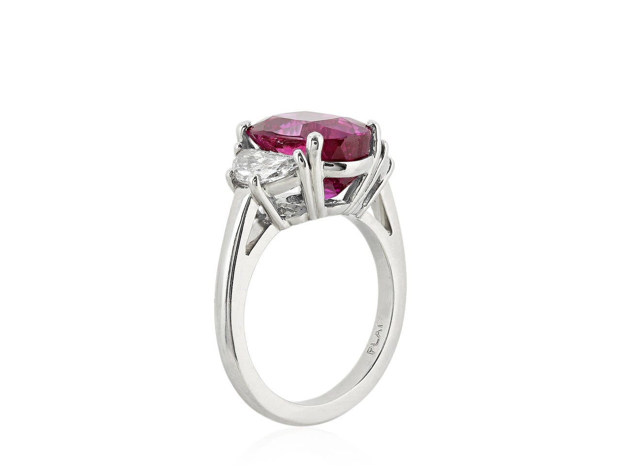 Platinum 3 stone ring consisting of 1 oval shaped purple pink sapphire weighing 6.44 carats, measuring 12.00 x 8.80 x 7.20mm with GIA certificate #1162052362 stating No Heat, the center stone is flanked by 2 brilliant cut half moons having a total