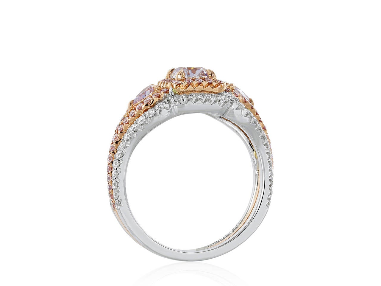 Two tone 18 karat yellow and rose gold 3 stone ring consisting of 1 radiant cut natural pink diamond weighing .93 carats, the center stone is flanked by 2 natural pink pear shape diamonds weighing .23 carats the 3 stones are set with .46 carats