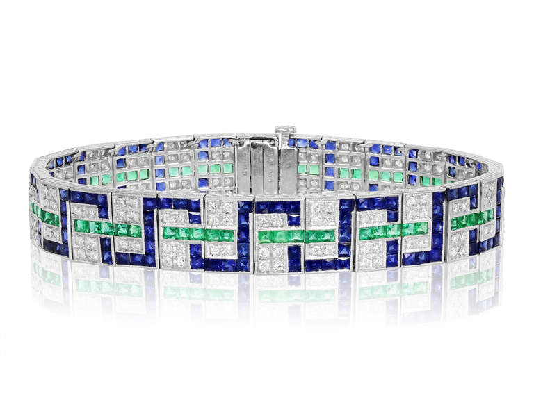 Platinum vintage style geometric bracelet consisting of 156 full cut diamonds having a total weight of 2.05 carats, set with 65 square cut emeralds and 169 square cut sapphires having a total weight of 18.80 carats