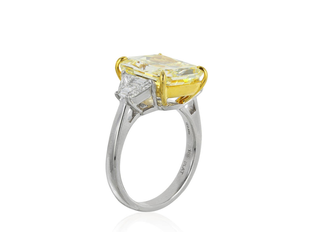 Custom made platinum and 18 karat yellow gold, three stone style engagement ring consisting of 1 radiant cut canary diamond, weighing 7.01 carats, measuring 12.19 x 10.36 x 6.27 mm, having a color and clarity of Fancy Yellow/SI2 with GIA report