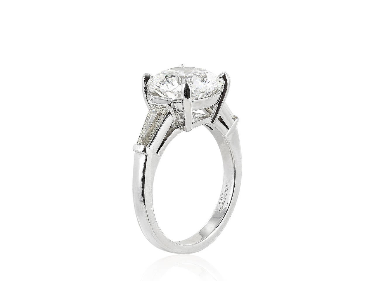Platinum three stone engagement ring consisting of 1 round brilliant cut diamond, weighing 4.04 carats, measuring 10.36 x 10.30 x 6.17, having a color and clarity of E/SI1 with GIA certificate #1152758941, with cut polish and symmetry grades of EX