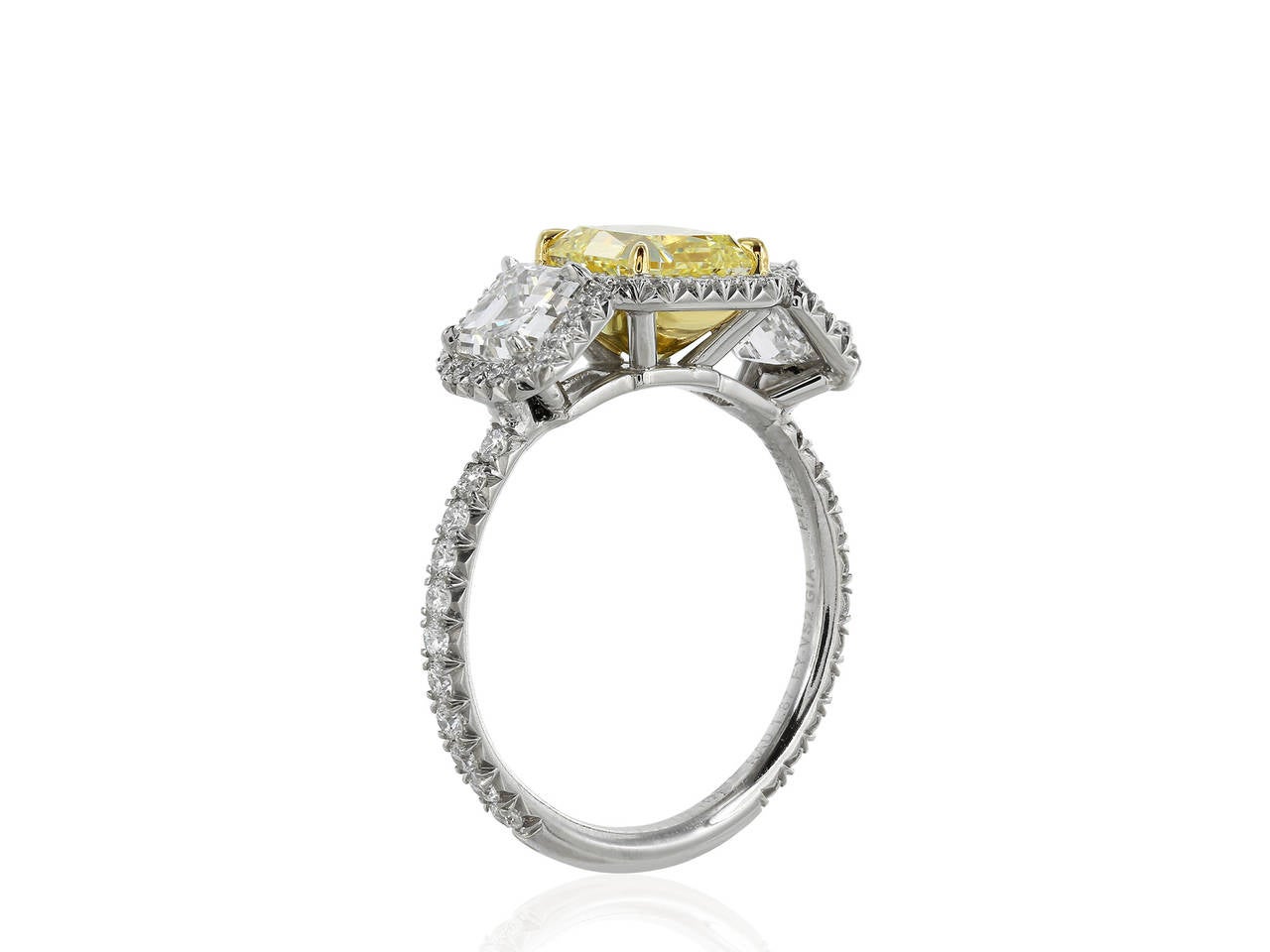Custom made, platinum and 18 karat yellow gold three stone engagement ring consisting of one radiant cut canary diamond weighing 1.87 carats, measuring 6.75 x 6.69 x 4.48 mm, having a color of Natural Fancy Yellow/VS2 with GIA report number