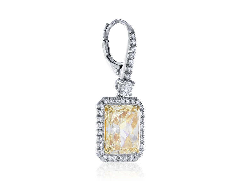 Platinum and 18 karat yellow gold drop earrings consisting of 2 radiant natural canary diamonds, 1 weighing 5.04 carats having a color and clarity of FLY/VS1 and 1 weighing 5.02 carats having a color and clarity of FLY/VS1, the center stones are set