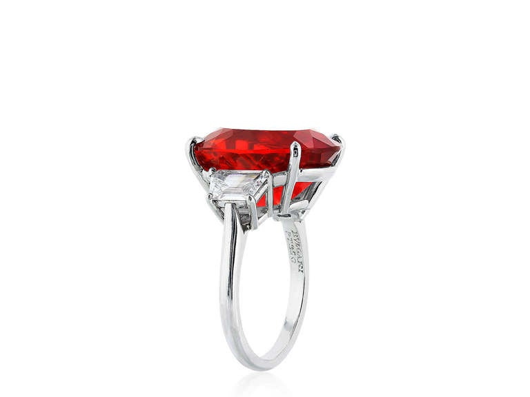 Platinum 3 stone ring consisting of 1 rare gem specimen oval shaped Fire Opal weighing 10.57 carat flanked by a pair of trapezoid cut diamonds weighing 1.50 carats three stone ring. signed Bulgari #c4033A
