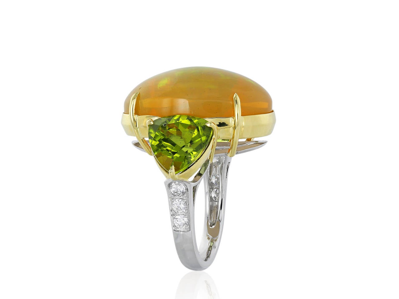 18 karat yellow gold 3 stone ring consisting of 1 cabochon oval shape fire Opal weighing approximately 17.18 carats, the center stone is flanked by trillion cut peridot side stone and 3 full cut diamonds on each side.
