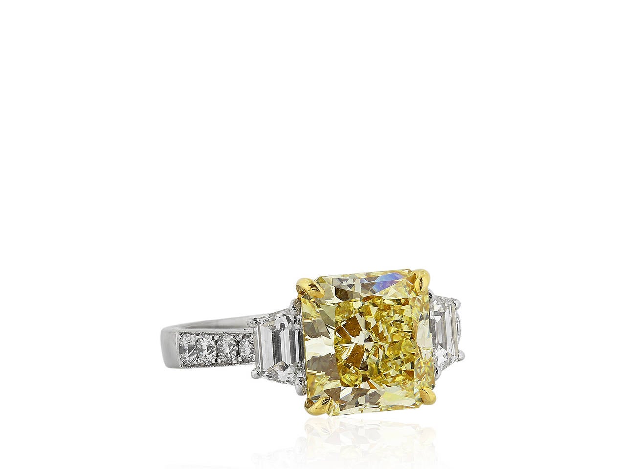 Platinum and 18 karat yellow gold 3 stone ring consisting of 1 radiant cut canary diamond weighing 3.77 carats having a color and clarity of FY / SI1 with GIA certificate #2125070218, the center stone is flanked by 2 step cut trapezoid diamonds and
