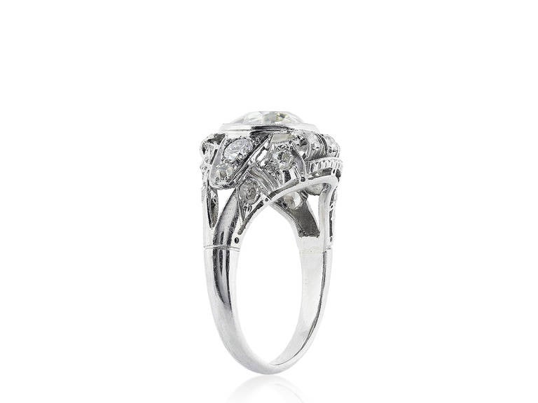 Platinum Art Deco ring consisting of 1 Antique cushion diamond weighing approximately 2.35 carats set in a filigree mounting with Old European cut diamond accents