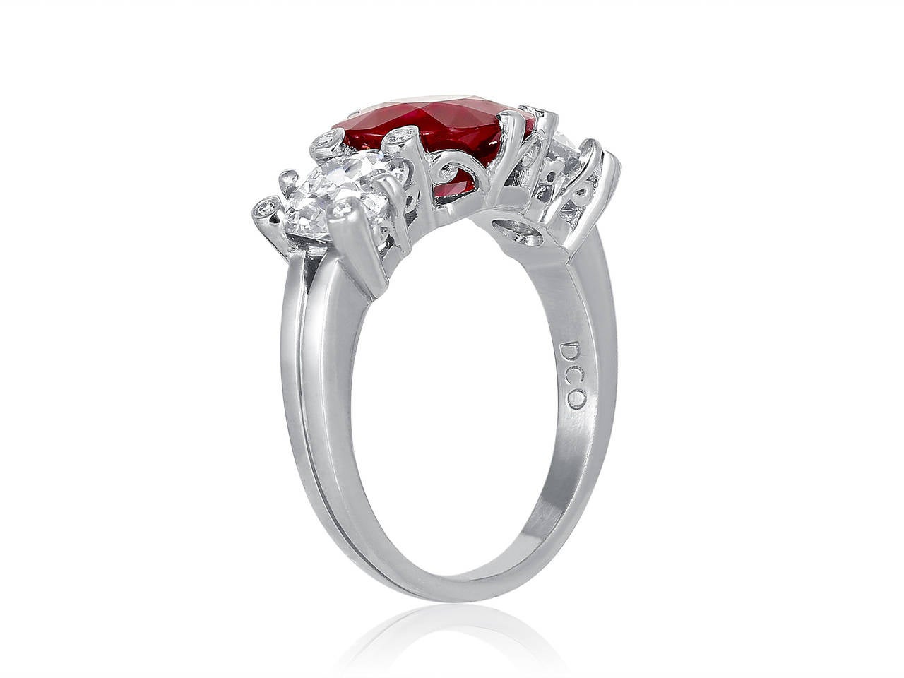 Platinum custom made 3 stone ring consisting of 1 cushion cut Burma ruby weighing 3.07 carats, measuring 8.58 x 8.53P x 4.49mm with AGTA certificate #98022509, the center stone is flanked by 2 old european cut diamond having a total weight of 1.80