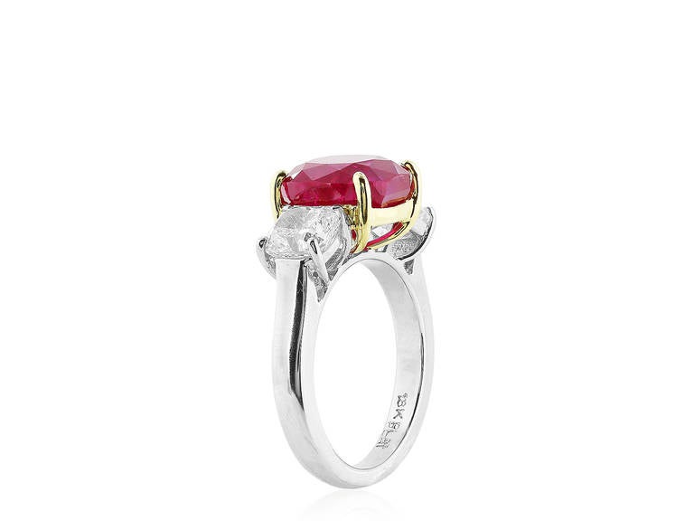 Platinum and 18 karat yellow gold 3 stone ring consisting of 1 cushion cut ruby weighing 5.77 carats with Gubelin certificate #13030035 stating origin Burma No Heat. The center stone if flanked by 2 cushion cut diamonds having a total weight of 2.02
