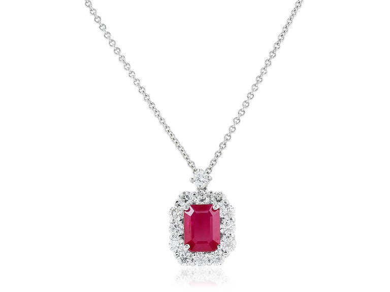 18 karat white gold pendant consisting of 1 emerald cut ruby weighing approximately 1.40 carats, the center stone is surrounded by 1 row of 13 full cut diamonds having a total weight of approximately 1.10 carats.