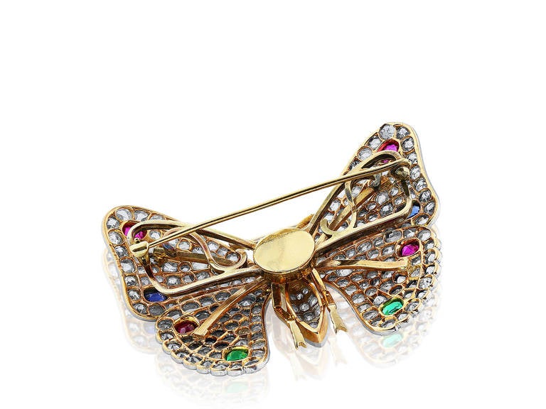 Platinum on gold Edwardian Rose cut diamond butterfly pin containing approximately 7ct in diamonds with ruby, sapphire, emeralds and one pearl.  Circa 1900.