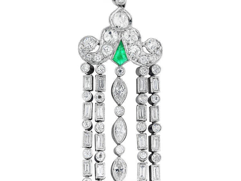 Platinum and 18 karat yellow gold Art Deco Chandelier earrings consisting of approximately 6.75 carats total weight diamond set with a custom cut emerald accent.